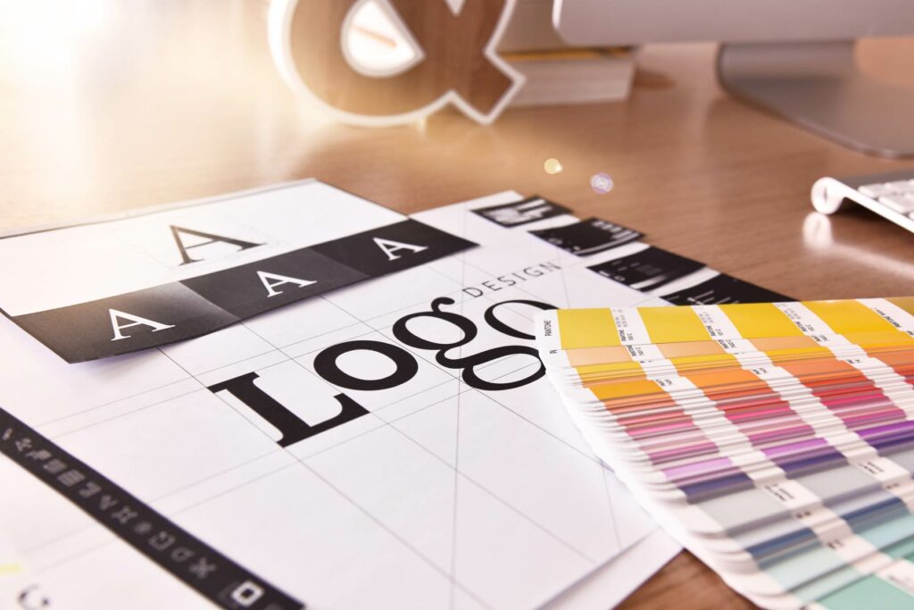 Schreibtisch mit Farbpaletten und Logodesign-Vorlagen